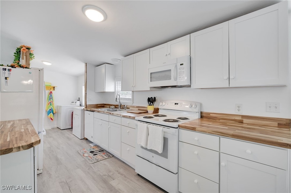 Kitchen with washer / dryer, white appliances, lig