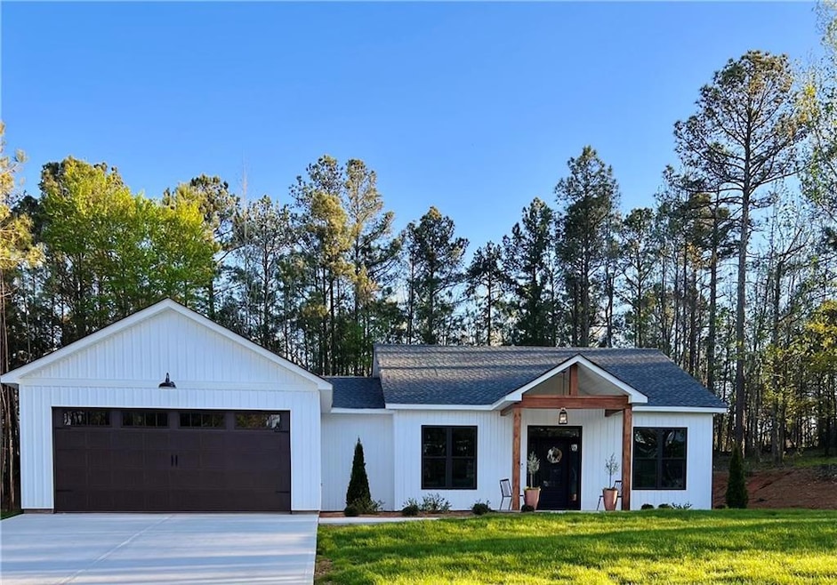 Modern inspired farmhouse featuring a front lawn a