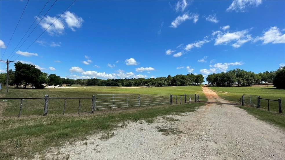 View of street with a rural view, a gate, and a ga