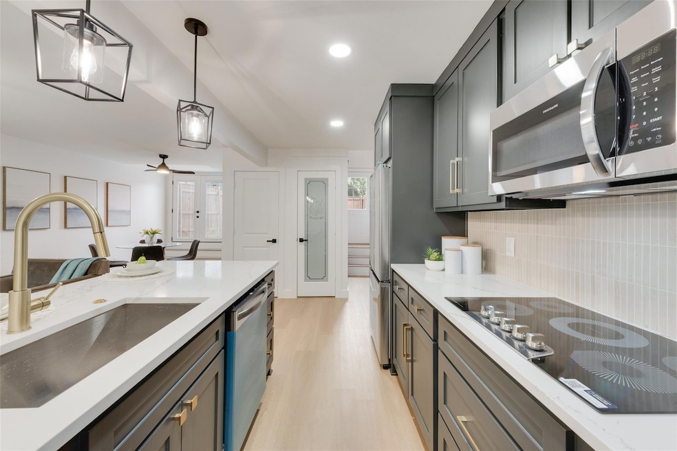 Kitchen with hanging light fixtures, appliances wi