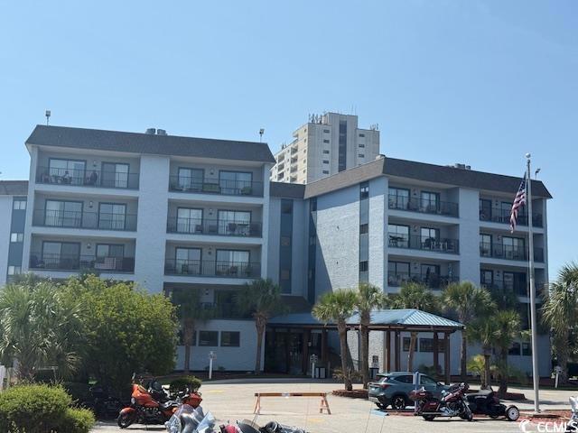 View of apartment building / complex with uncovered parking