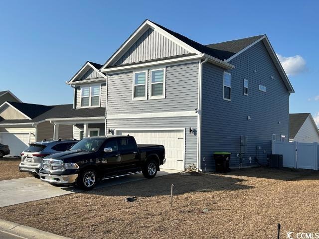 Exterior space with a garage and central air condi