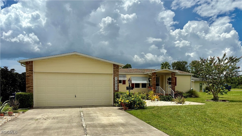 Single story home featuring concrete driveway, a front yard, a garage, and brick siding