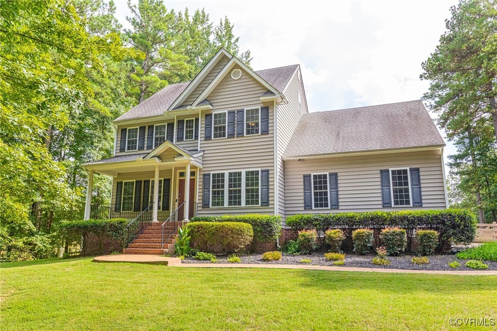 View of front facade featuring a front yard and covered porch