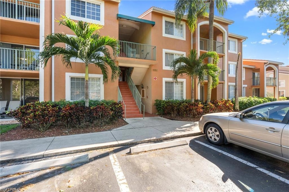 View of building exterior featuring uncovered parking and stairway