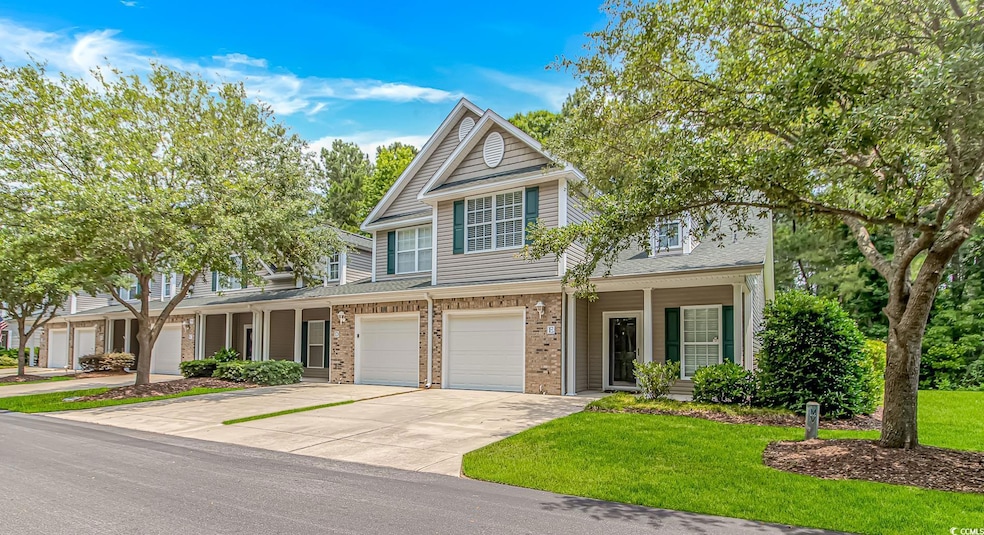 Multi unit property with concrete driveway, an attached garage, a porch, a shingled roof, and brick siding
