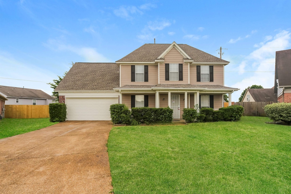 Traditional-style house featuring an attached garage, concrete driveway, roof with shingles, and covered porch