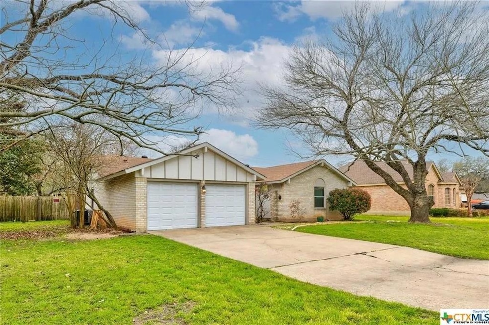 Ranch-style house featuring brick siding, board and batten siding, concrete driveway, and a garage