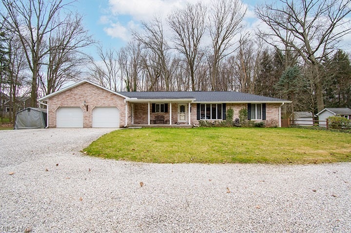 Ranch-style house with a porch, a front lawn, and a garage