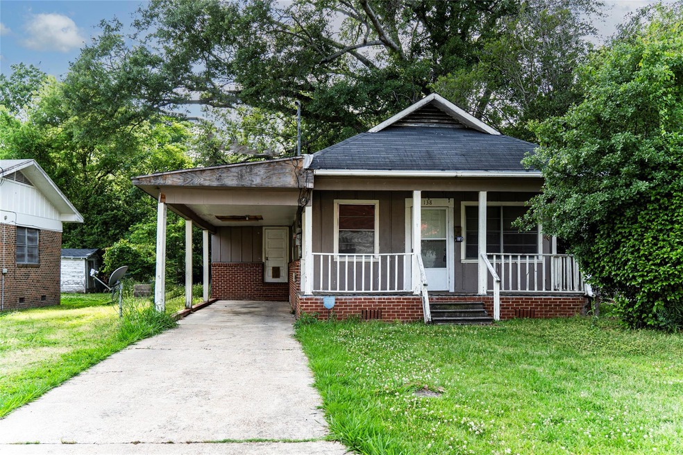 Bungalow featuring a front yard, a carport, and a 