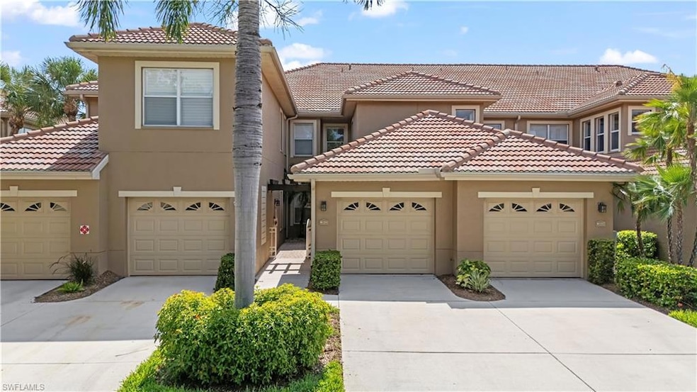 Townhome / multi-family property featuring a tiled roof, stucco siding, driveway, and a garage
