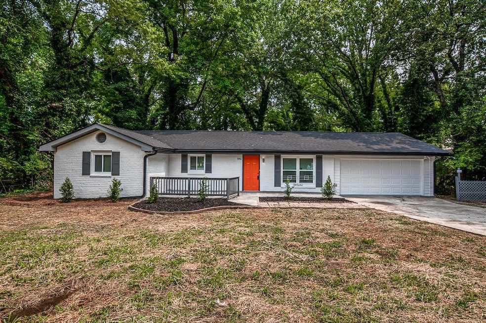 Ranch-style home with covered porch, an attached garage, driveway, brick siding, and a front lawn