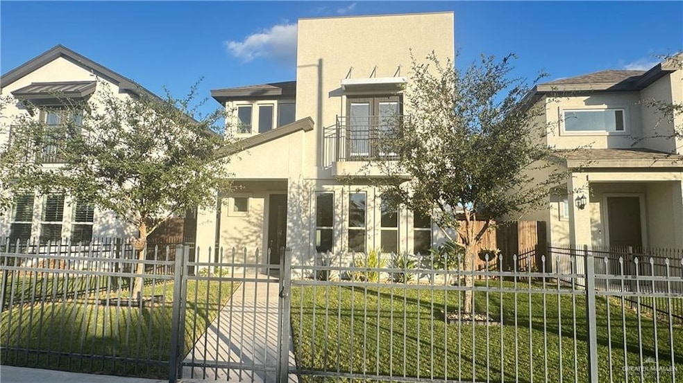 View of front of property featuring a fenced front yard, stucco siding, and a balcony