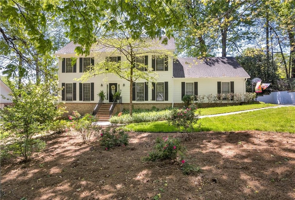 Colonial home with brick siding, roof with shingle