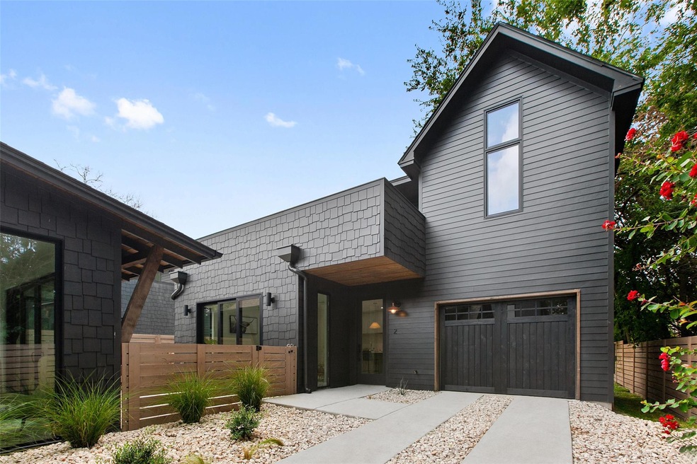 Contemporary house with fence, a garage, and driv