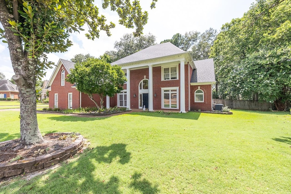 Neoclassical home featuring brick siding and a shingled roof