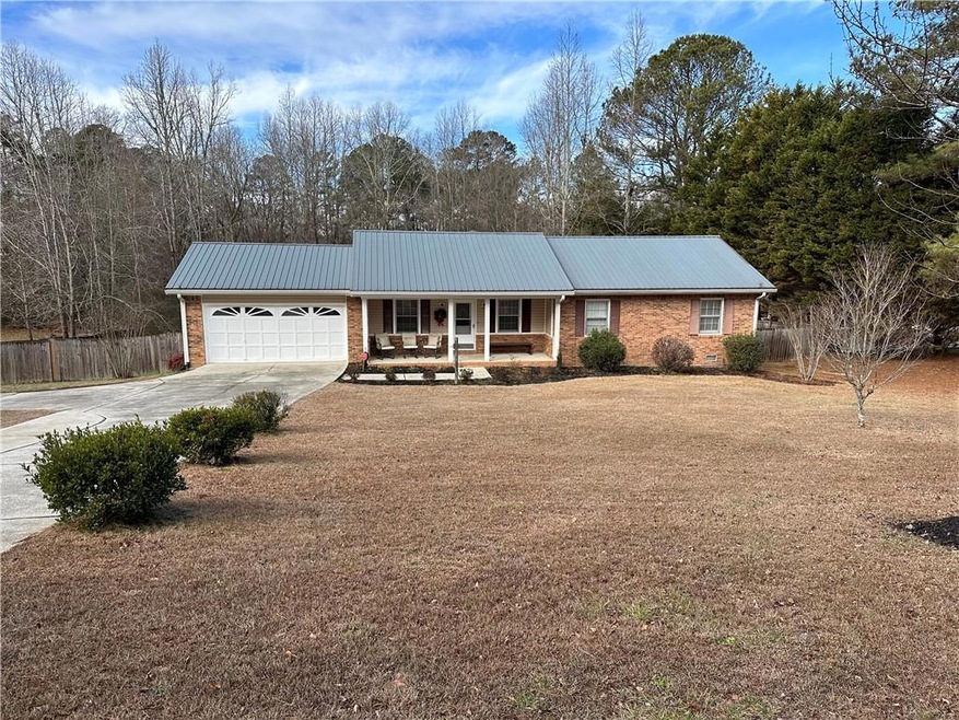 Ranch-style home with a garage and a porch