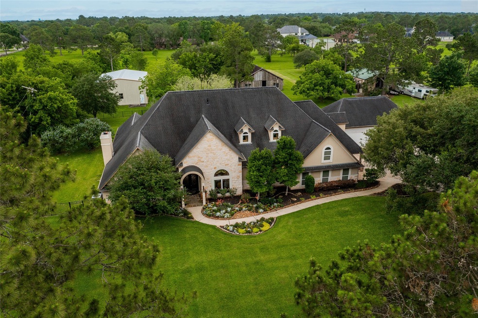 Estate living on 2 sprawling acres in the heart of Friendswood! A lush lawn dotted with mature shade trees, a pool, outdoor kitchen, wood loft-style barn, & a metal outbuilding surround this more than 5000 square foot residence.