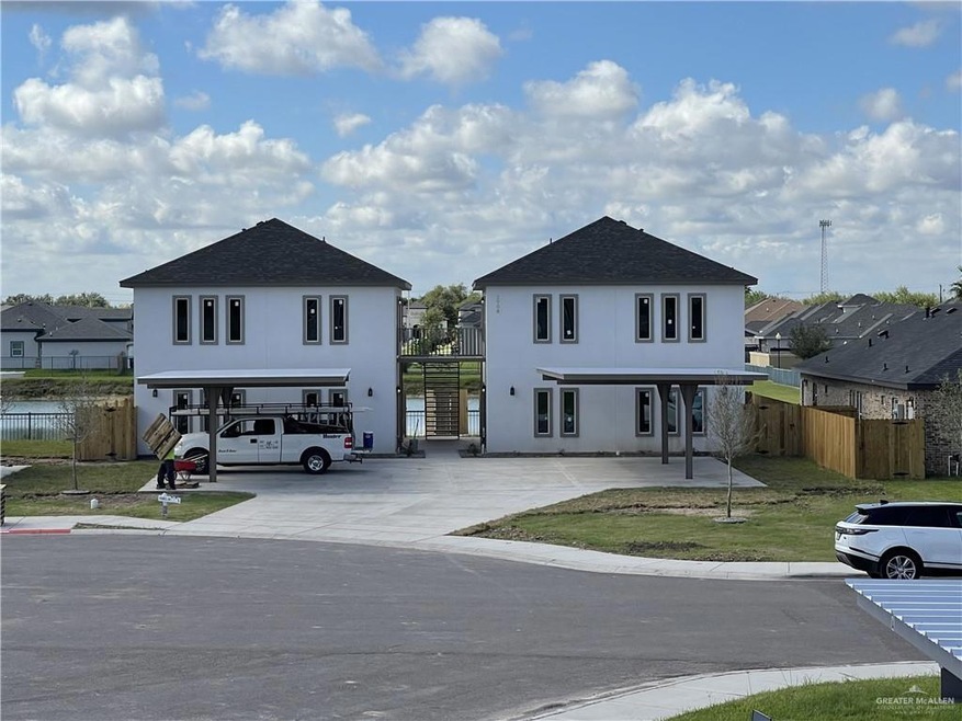 View of front of property with stucco siding, concrete driveway, a front yard, fence, and a residential view
