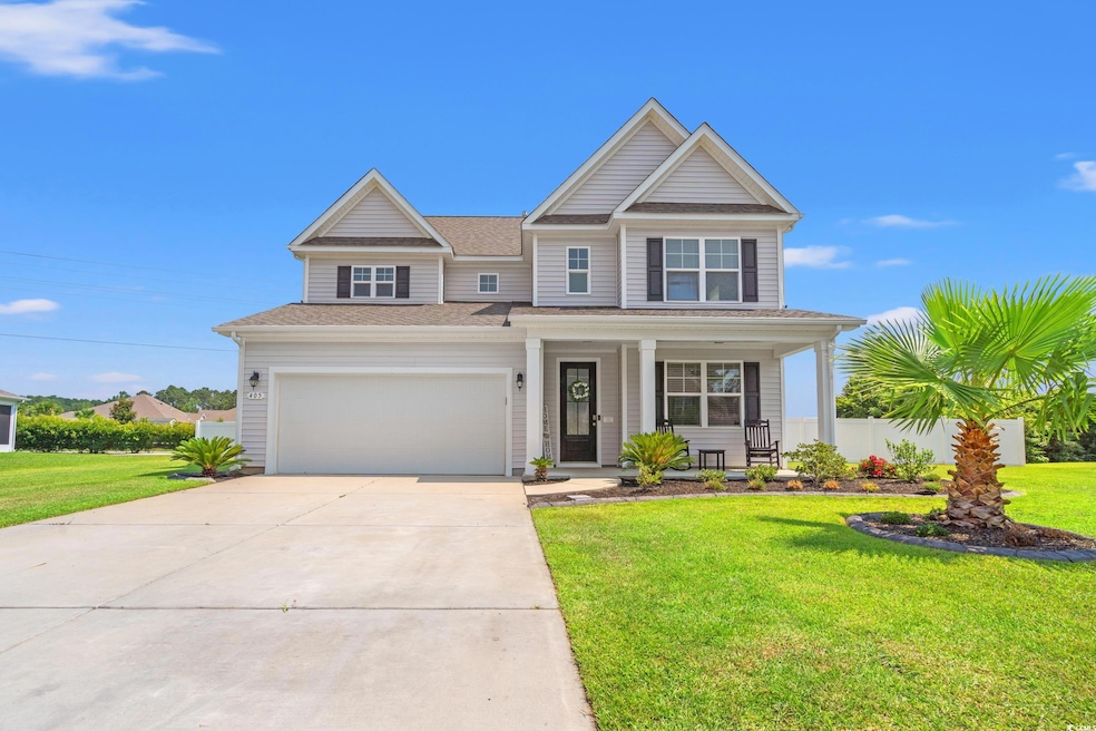 View of front of property with driveway, a porch, a front yard, a shingled roof, and a garage