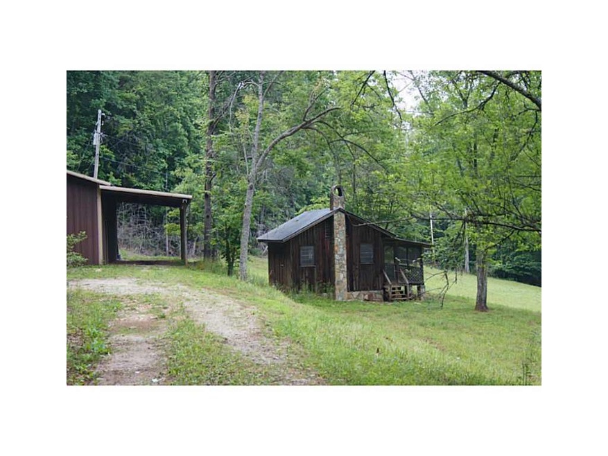 Exterior Front. One room cabin with large shop in 