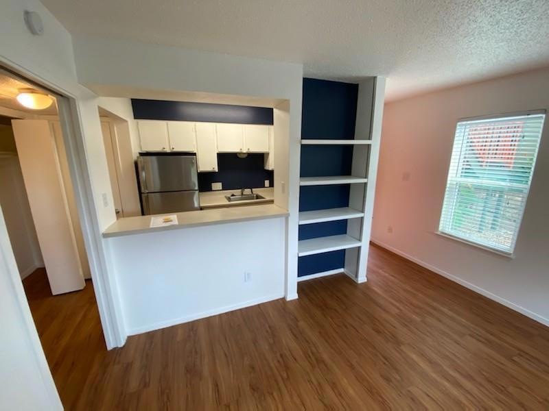 Kitchen featuring freestanding refrigerator, dark