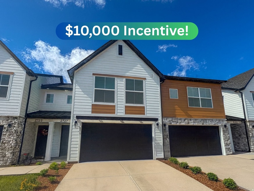 Contemporary home with stone siding, driveway, and an attached garage