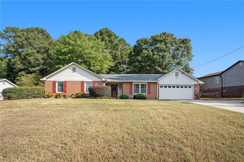 Ranch-style house featuring a garage and a front y