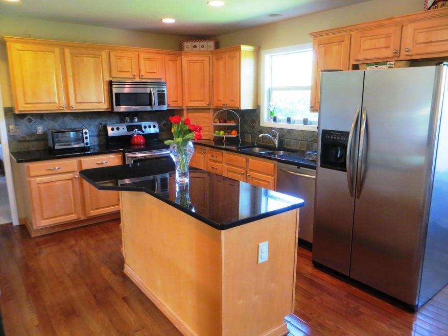 Island kitchen featuring new hardwood fl
