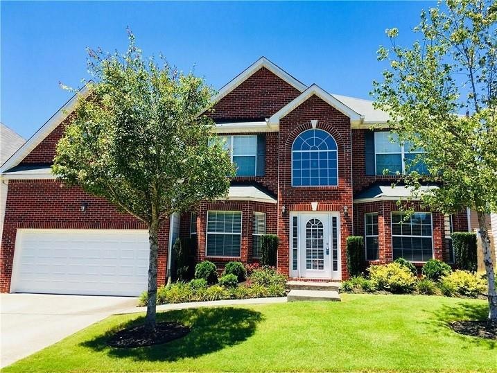 View of front of home with a front lawn and a garage