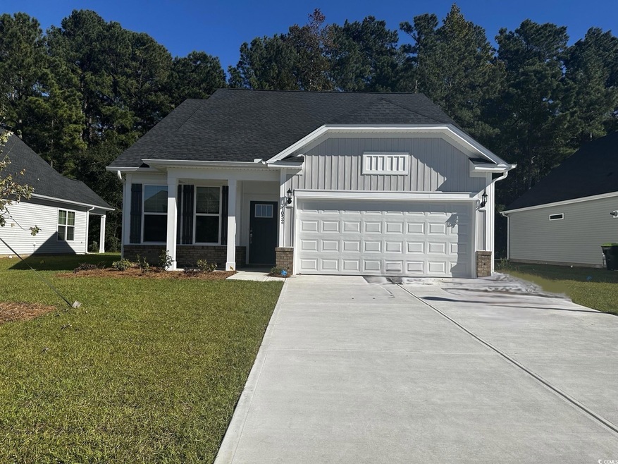 View of front of house with a front yard and a gar