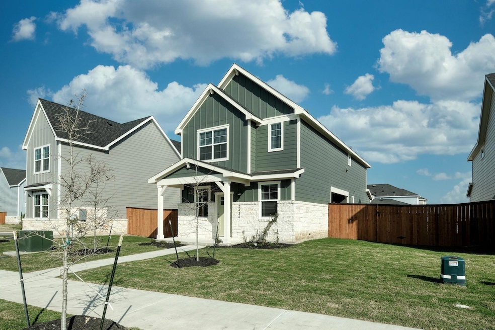 Craftsman inspired home with fence, a front yard, stone siding, and board and batten siding