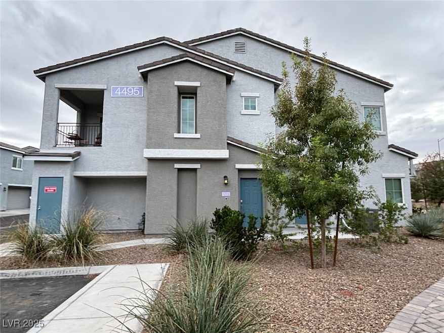View of front of home with a balcony and stucco siding