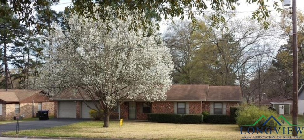 Ranch-style house featuring aphalt driveway, a gar