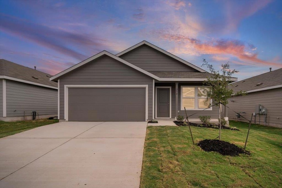 Single story home with driveway, a front yard, and a garage