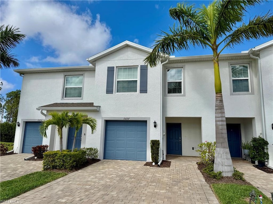 View of front of property featuring stucco siding, an attached garage, and decorative driveway