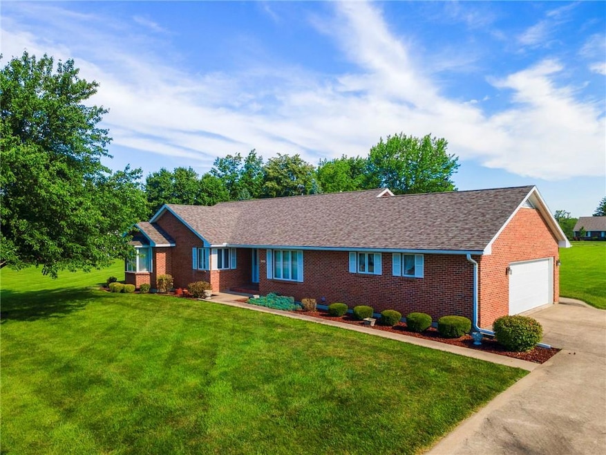 Ranch-style home with brick siding, a front lawn, driveway, a garage, and roof with shingles