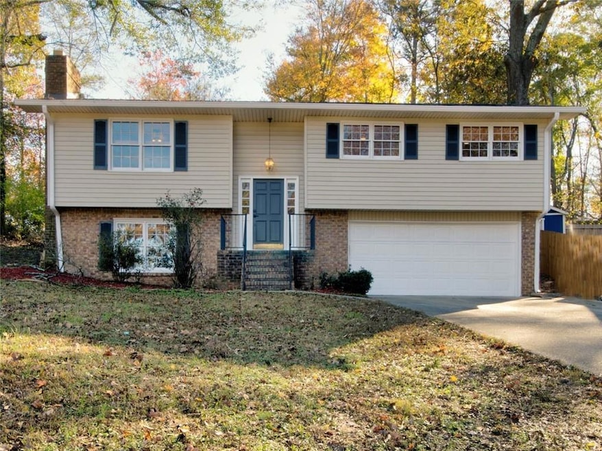 Split foyer home with a garage and a front yard