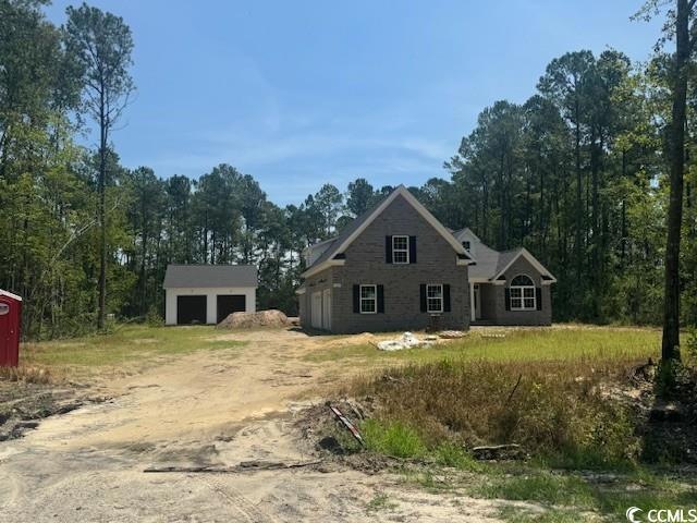 View of front of home featuring an outbuilding and dirt driveway