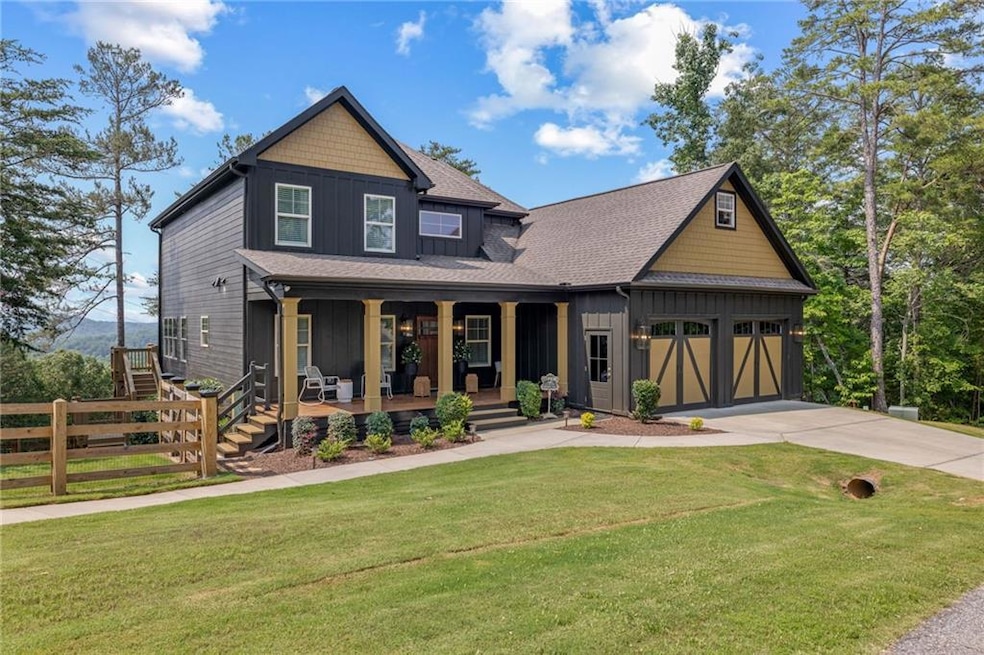 Craftsman-style house featuring board and batten siding, a porch, driveway, an attached garage, and a shingled roof