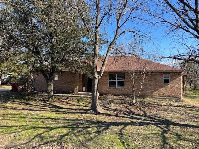 View of home's exterior featuring brick siding and a lawn