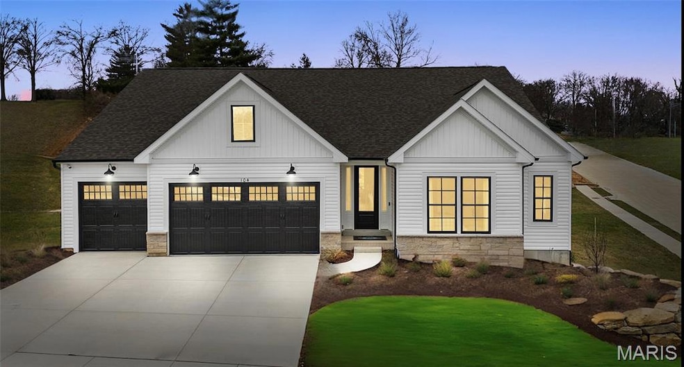 Modern farmhouse with a shingled roof, stone siding, and concrete driveway