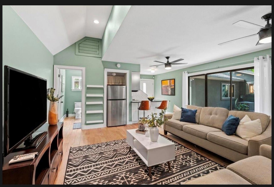 Living room with a ceiling fan, light wood-type f