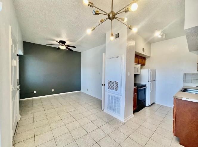 Kitchen featuring white appliances, a textured ce
