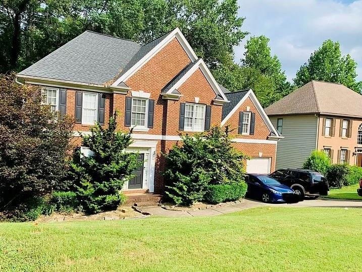 View of front facade with a garage and a front law