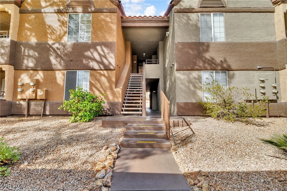 View of exterior entry with a tile roof and stucco
