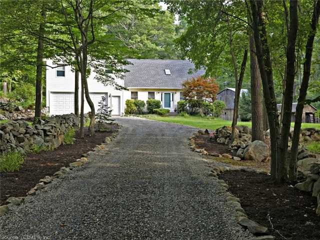 Exterior Front. Driveway lined with gardens and st