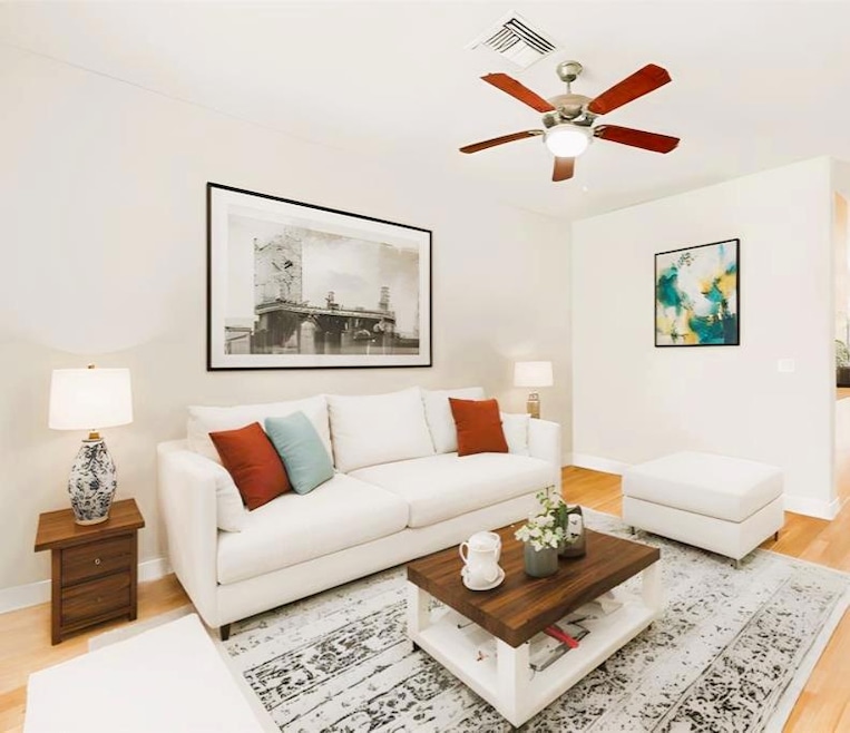 Living area featuring light wood-type flooring and a ceiling fan