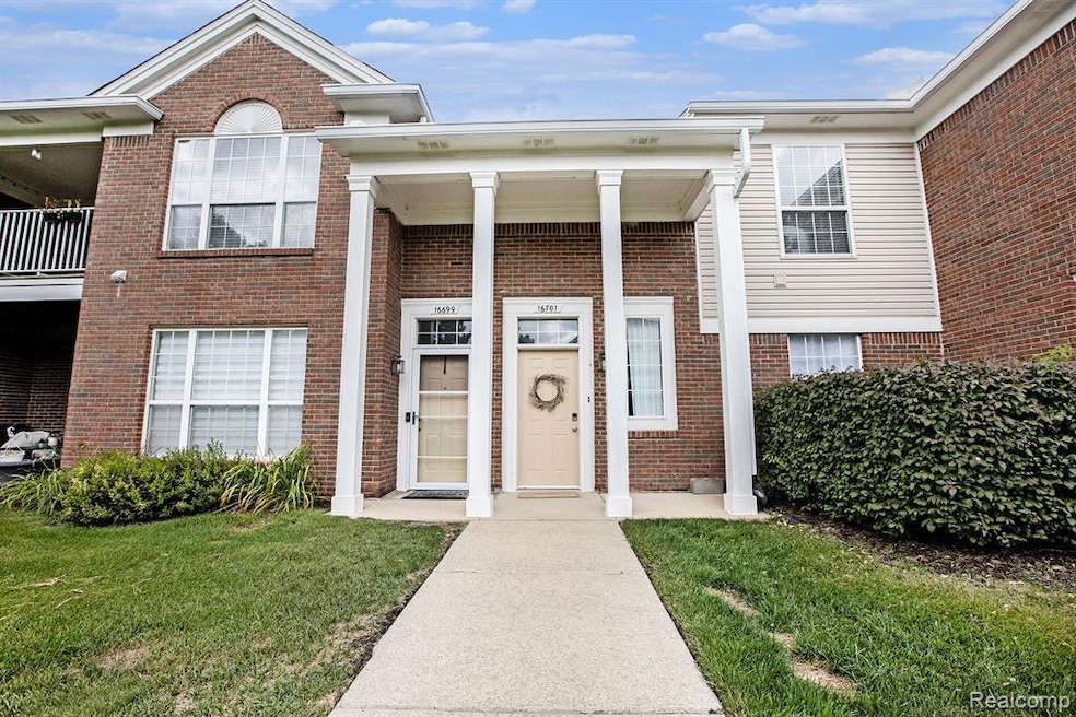 View of exterior entry with brick siding and a lawn