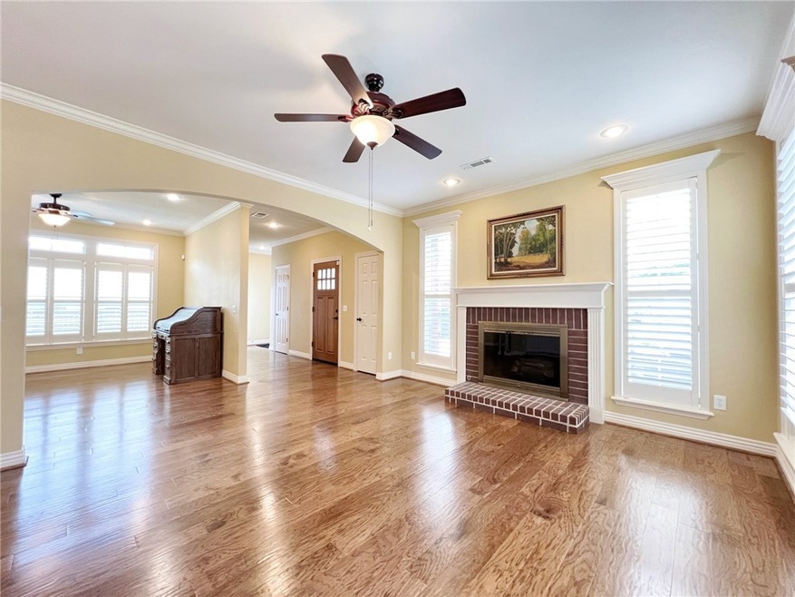 Living room with brick fireplace, built ins, crown